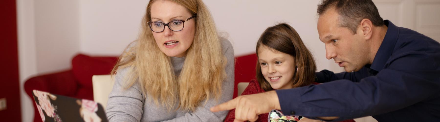 Parents helping their child on the computer